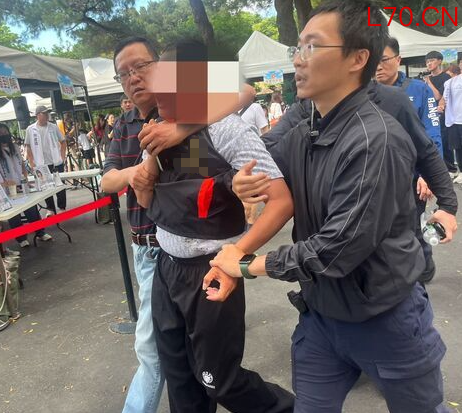 游兆霖（中）5月23日朝柯文哲砸鸡蛋被警方带走。图源：台媒